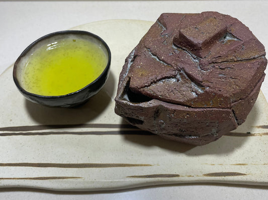 japoniško wabi-sabi stiliaus arbatinukas ir arbata puodelyje
